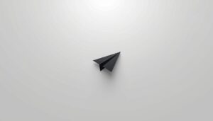 Minimalist black paper airplane on a light grey background symbolizing minimum viable distribution and focused reach
