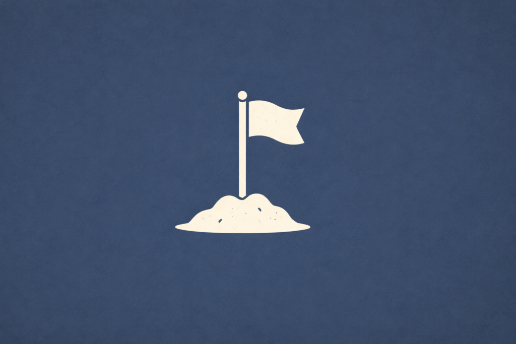 Minimalist beige flag planted in a small mound on a deep navy background, symbolizing the start of building from scratch.