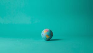 Toy globe on a neon teal background symbolizing global AI impact