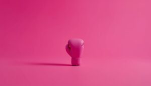 Toy boxing glove on a neon pink background symbolizing competition with AI-powered workers.